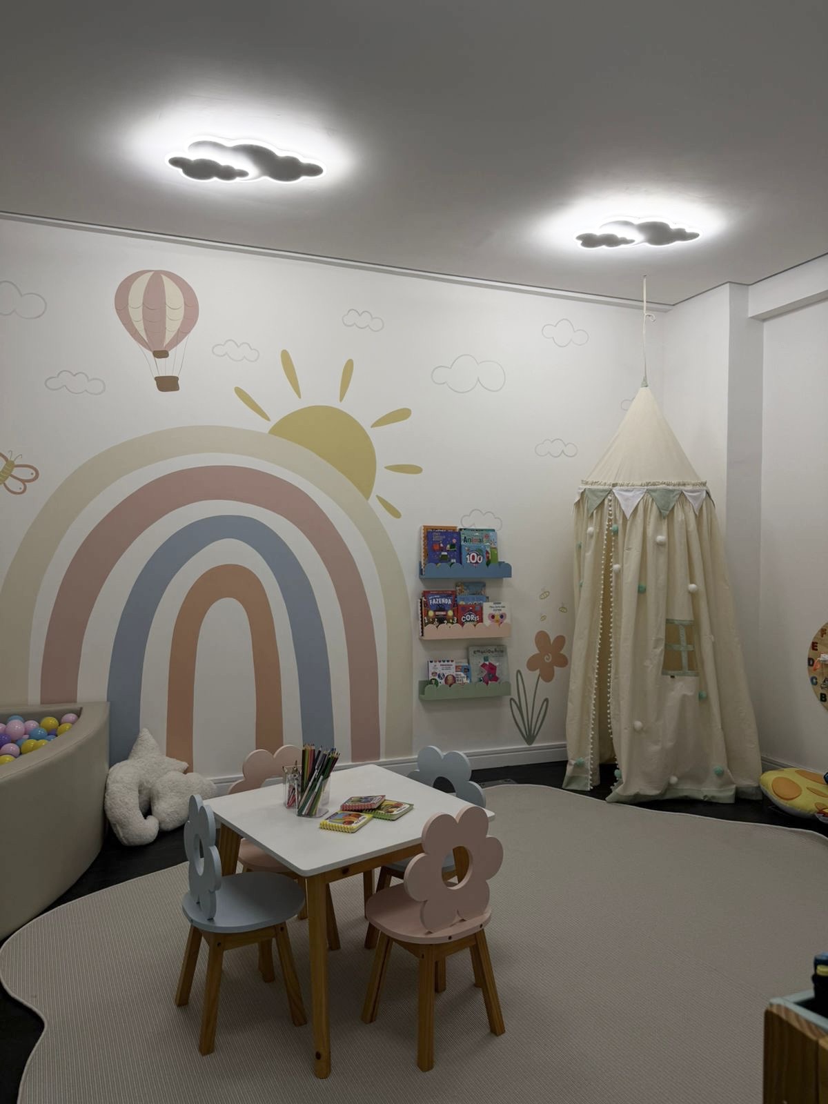 Sala de brinquedos da Clinica VOLARE com mural de arco-iris